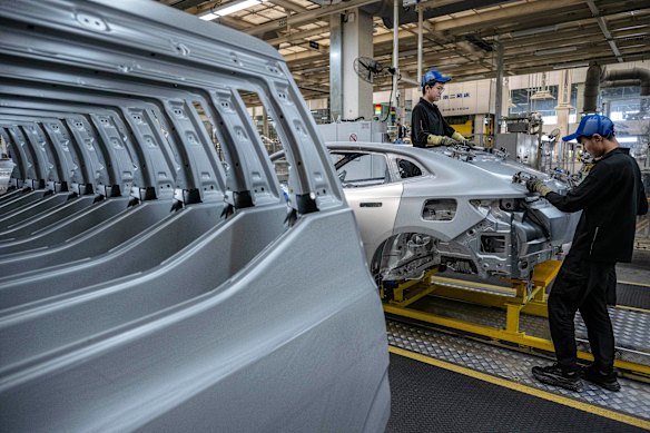 Workers assemble part of a frame on the production line for electric vehicle maker Zeekr at its factory in Ningbo, China.