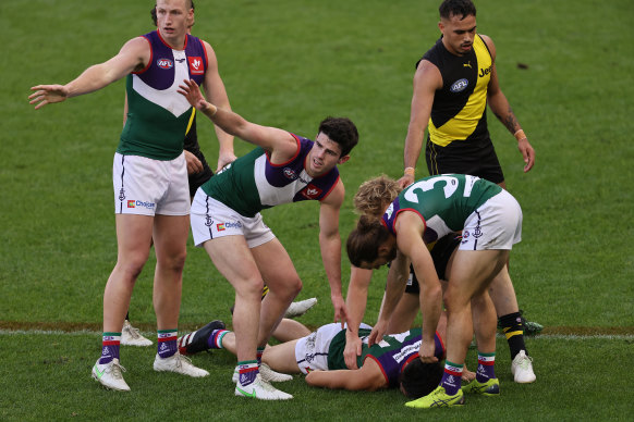 Josh Treacy and Andrew Brayshaw call for the stretcher for teammate Bailey Banfield after he was knocked out.