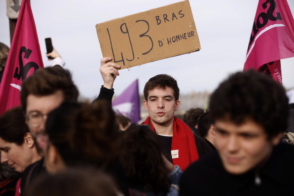 A protester holds a placard during a gathering at Concorde square near the National Assembly in Paris.