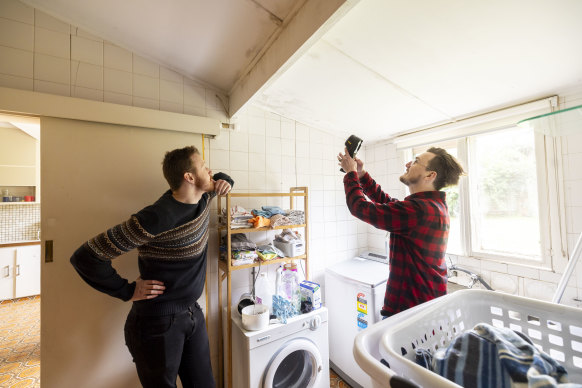 Jordan van den Berg uses a handheld thermometer to check for the source of mould in Hudson’s home. 