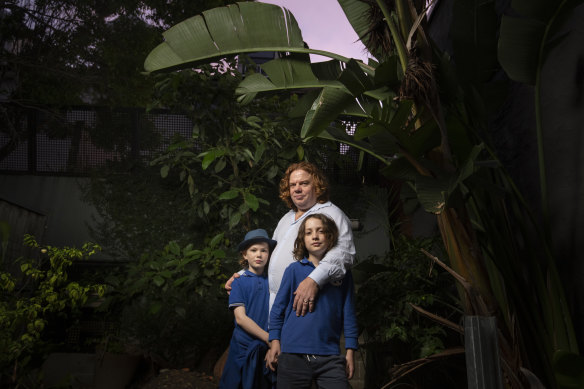 Reuben Merricks with his children Eliza, 9 and Miles, 8 in Newtown. He is keeping his extra food supplies at work.