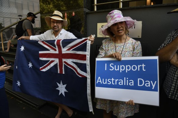 Two counter-protestors stand across the road from the Invasion Day demonstration.