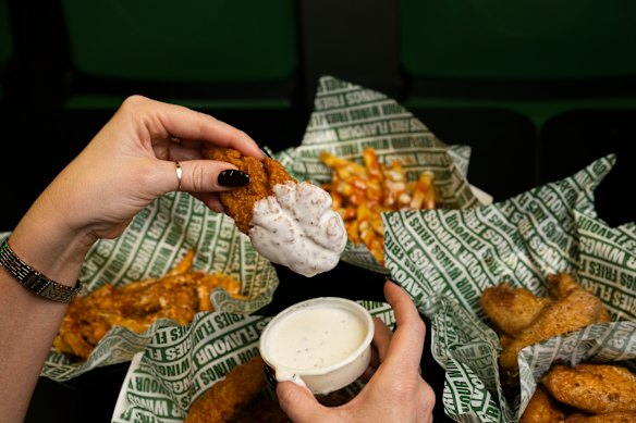 Hot honey tenders being dipped into ranch sauce. 