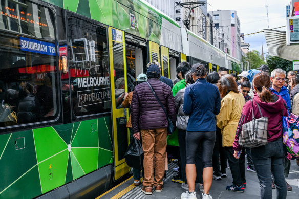 Passengers waiting to board a packed tram in the free zone on Friday.