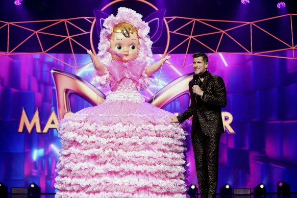 Osher Gunsberg with one of the many outrageously clad performers in The Masked Singer.