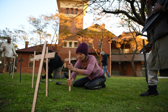 Homelessness advocates and rough sleepers install 56 crosses outside of Dumas House.