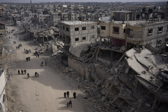 Palestinians walk through a destroyed Khan Younis this week.