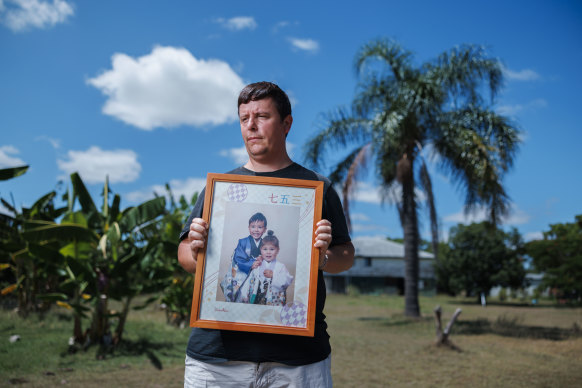 David Fleming holds a picture of his abducted children at his rural property outside of Brisbane.