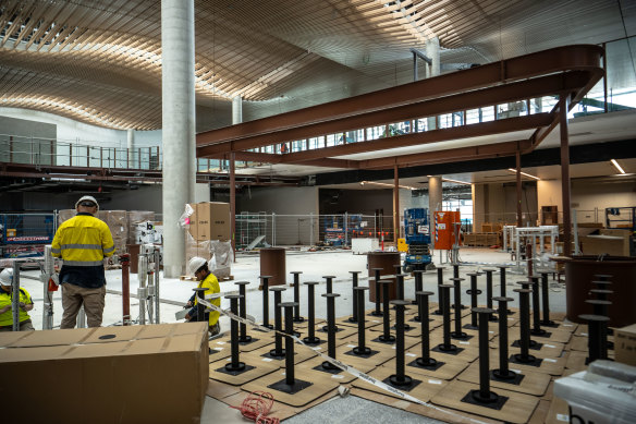 Workers install tables on the first floor where shops, restaurants and bars will be located.