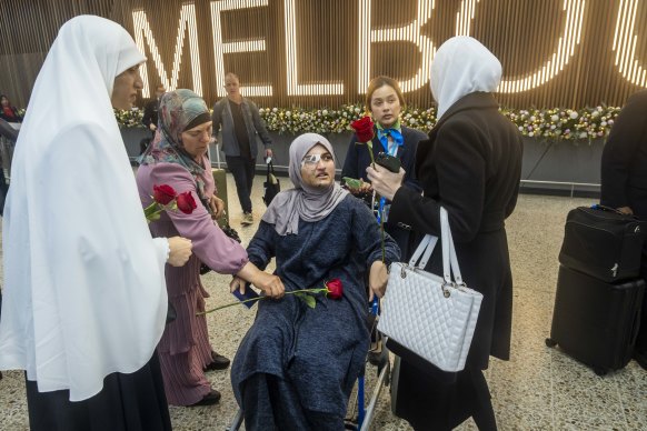 Friends and family members give Abu-Izneid roses after her arrival home.