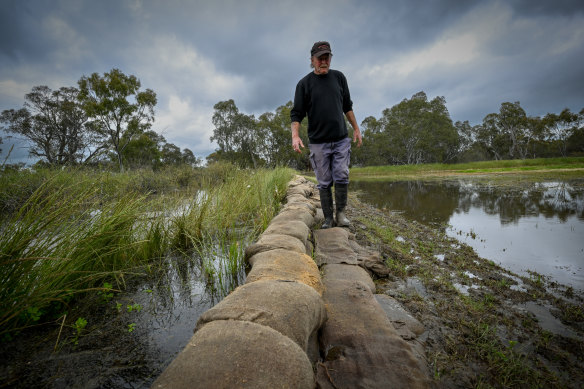 Clancy Watts defends his property against the rising water.