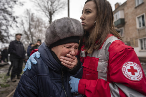 A woman cries in front of the building that was destroyed by a Russian attack in Kryvyi Rih, Ukraine on Friday.
