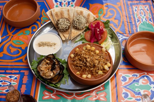 The mixed plate to share, with koshari, falafel, fried eggplant, salad with pickles, bread and tahini.