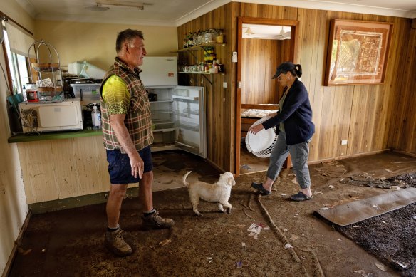 Amanda Waller  and Paul Trudegett go through the sodden and muddy remains of their home in Canowindra.