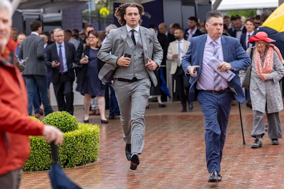 First racegoers jog for a place at Flemington racecourse for Cox Plate race day.