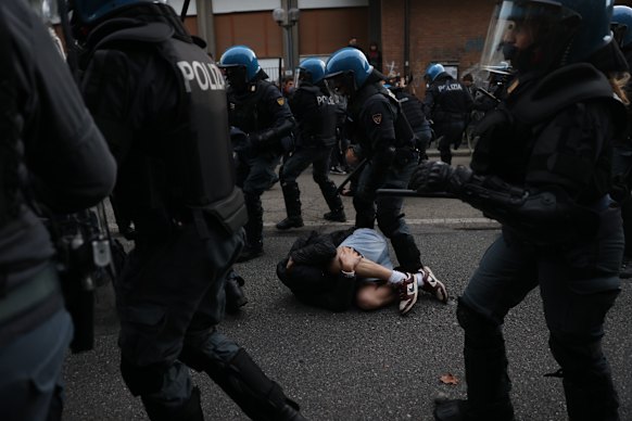 Un uomo giace a terra mentre la polizia di Torino affronta i manifestanti durante la protesta contro l'aumento del costo della vita e il deterioramento dei servizi pubblici durante una delle numerose proteste in tutta Italia.