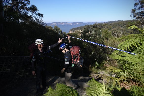 Police rescue workers assess the stability of the walking track before recovering the bodies on Tuesday.