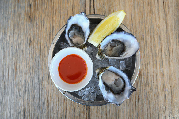 Oysters with a side of lemon and house-made sriracha. 