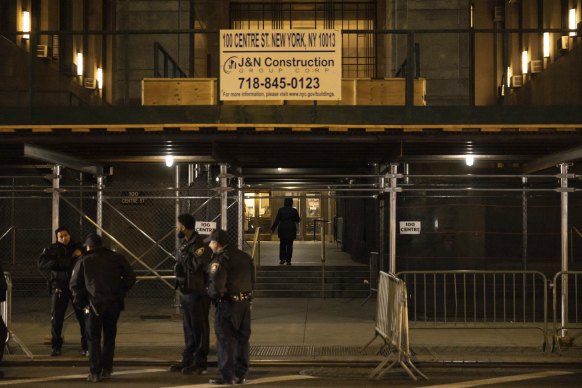 Police officers stand outside Manhattan Criminal Court in New York.