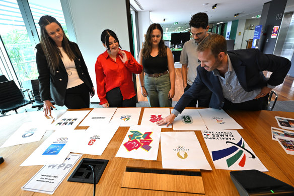 The interns look over previous Olympic and Paralympic emblems, with Brisbane 2032’s Rebecca Masci (left) and VML managing director Adam Kennedy (right).
