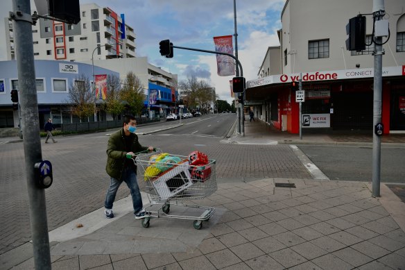 A shopper wheels a trolley through quiet Fairfield streets.
