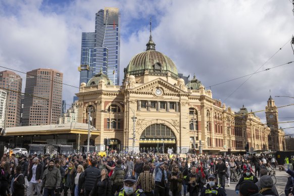 Anti-lockdown and anti-vaccine protesters out the front of Flinders Street Station on Saturday. 