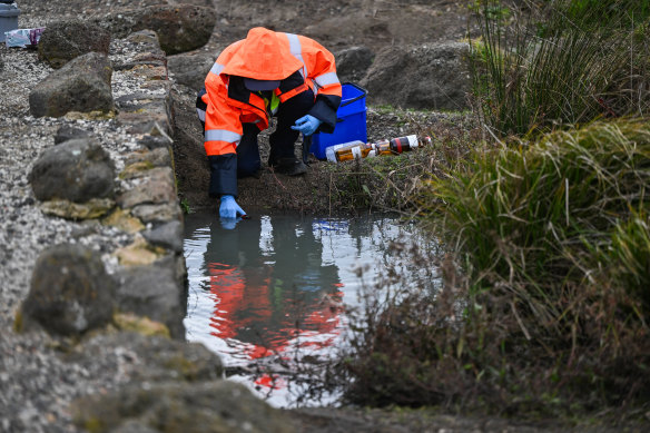 An EPA worker tests a creek on Thursday that runs through the Mount Derrimut golf course.