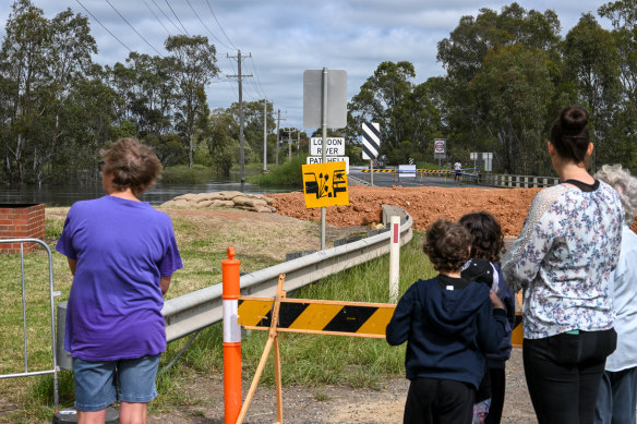 Kerang locals watch the Loddon River rise as the Patchell Bridge on the Murray Valley Highway remains closed due to the floods.
