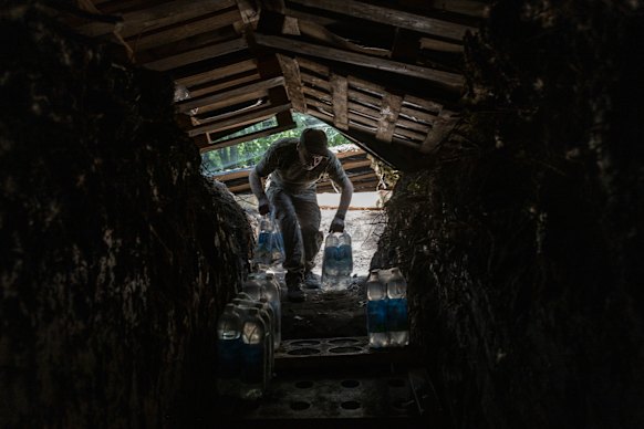 O 33º soldado de brigada mecanizado separado na Ucrânia move as provisões no bunker no lugar perto de Pokrovsk.