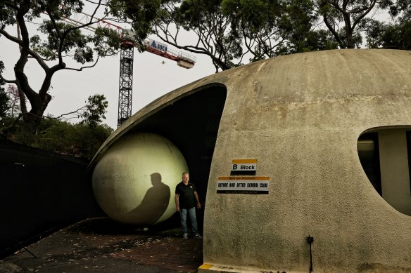 North Narrabeen Public School principal Adam Hughes with the “pearl of knowledge” . The binis a rare example of an unusual building technique by Dante Bini. They are being restored.