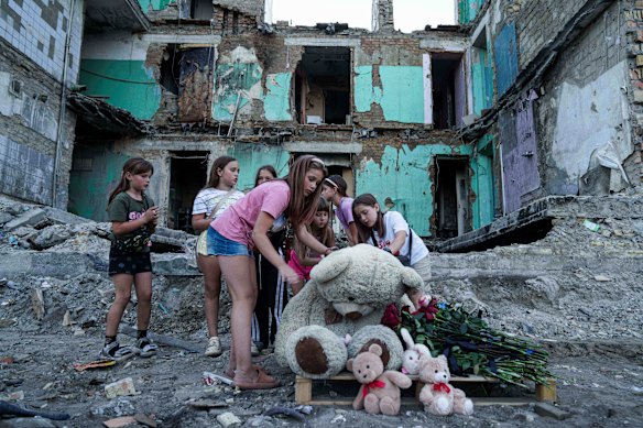 As meninas limpam a poeira de um ursinho de pelúcia na frente de uma casa que foi destruída por uma greve russa em Kiev, Ucrânia, na semana passada.
