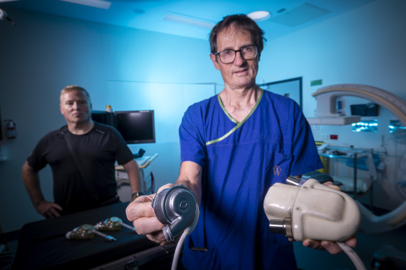 Professor David Kaye, director of cardiology at The Alfred with some of the first heart pumps used, and patient Peter Callinan, whose heart pump is top of the range right now.