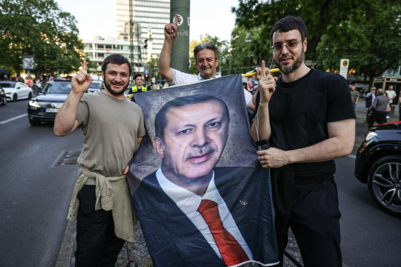 Turkish people in Germany celebrate along Kurfürstendamm avenue after preliminary results in Turkey’s general election run-off indicated a win for Recep Tayyip Erdogan.