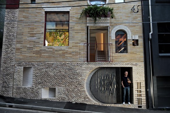 Architect Adam Haddow at the front of his Surry Hills home. The award-winning painting by Nicholas Harding can be seen through the window. 