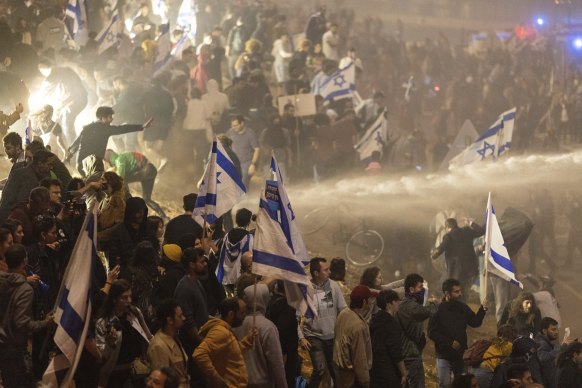 Israeli police use a water cannon to disperse demonstrators blocking a highway on Monday.