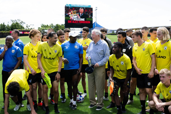 Sir Alex Ferguson speaks to the  Macarthur FC squad, coached by Dwight Yorke, at Cambelltown Stadium.