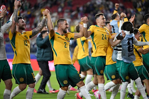 Socceroos players celebrate their progression to the round of 32.
