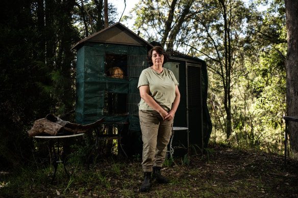Liz Martin, a former WIRES carer who has left the organisation after 10 years, standing before now-empty rehabilitation cages for possums and gliders.
