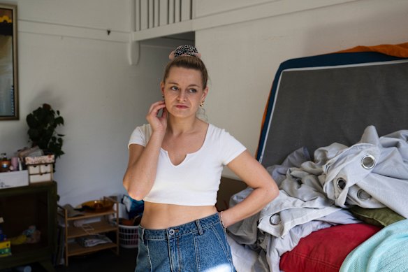 Holly Konopka in her rented Coogee apartment. She has had to move her bedroom furnishings into the lounge room because of mould growing on the ceiling. 