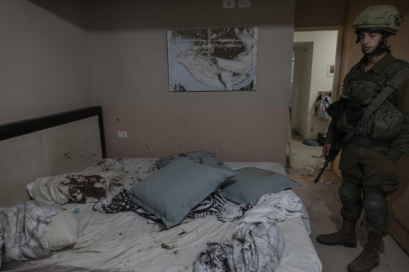 Israeli soldiers inside the bedroom of a home where people were killed by Palestinian fighters at Kibbutz Be’eri near the Gaza border on October 14, 2023. 