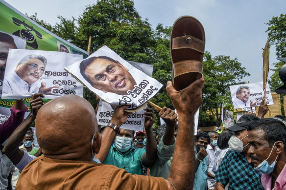 Thousands demonstrate against the government of Gotabaya Rajapaksa, seen in signs at left and right, over power cuts and the lack of essential products in Colombo.