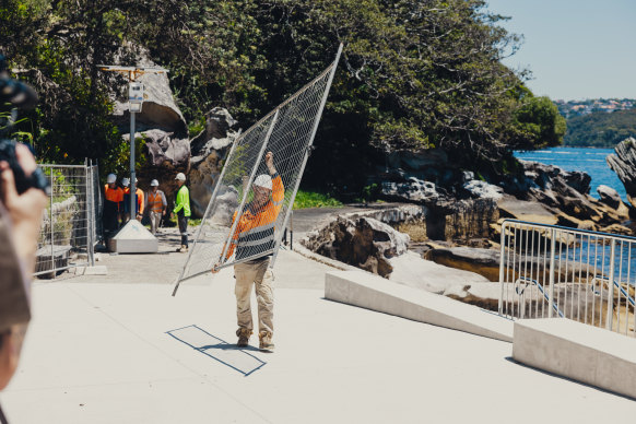 Construction workers remove fencing before the opening on Thursday.
