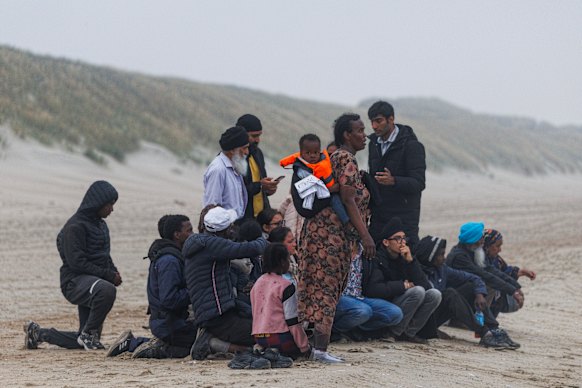 Os migrantes esperam ansiosamente por um pequeno barco para colecionar da praia nos Graelines, na França, na quarta -feira.