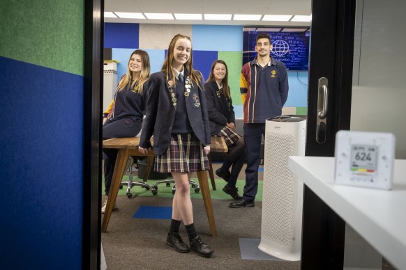 Grace Plecas, 17, Isabel Hrvatin, 17, Jade Simunija,18, and Jaiden Calleja, 17, with one of the carbon dioxide monitors at Catholic Regional College in Sydenham.