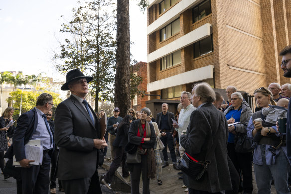 Residents and owners with Land and Environment Court Commissioner Peter Walsh outside the apartments in Elizabeth Bay on Wednesday.