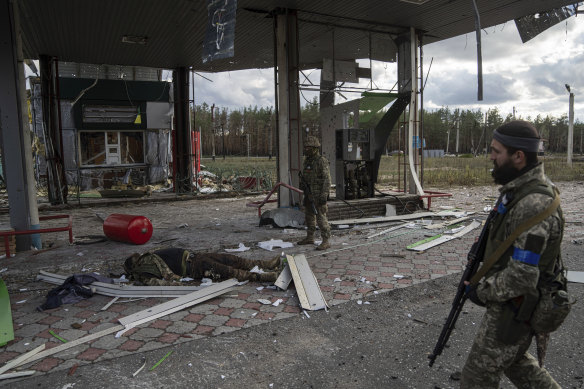 Ukrainian servicemen find a body of their comrade on the destroyed petrol station in the recently recaptured town of Lyman, Ukraine.