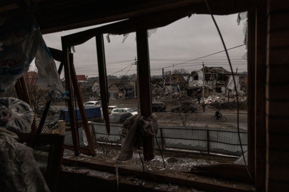 A person rides a bicycle next to damaged residential houses following the Russian missile attacks.