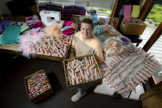 Lauren Stott and some of the 1500 cupie dolls she is clothing for sale at the Royal Melbourne Show.