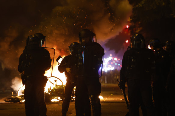 Police officers stand by burning bicycles during tensions near Place de la Republique following the second round of the legislative elections on July 7. 