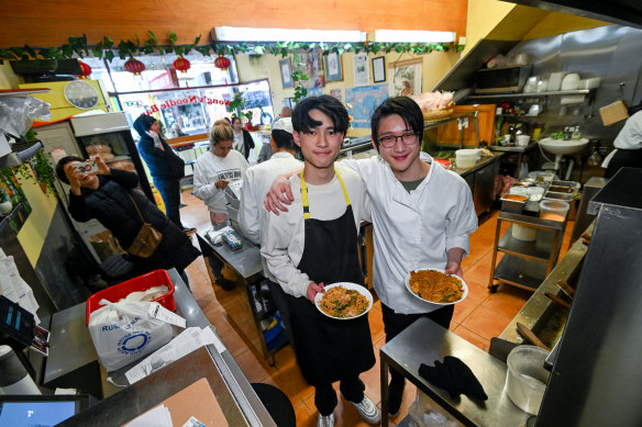 Kim Zhu and Kerry Zhu (with glasses) both working at their parents Bentleigh noodle shop on Monday evening after receiving a perfect ATAR ranking.